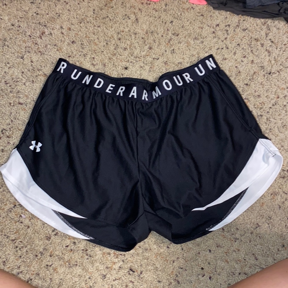 Black Under Armor gym shorts. White accents. Thick waistband. Pockets.